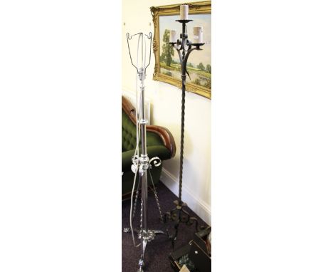 A wrought iron floor lamp together with another similar chrome example.