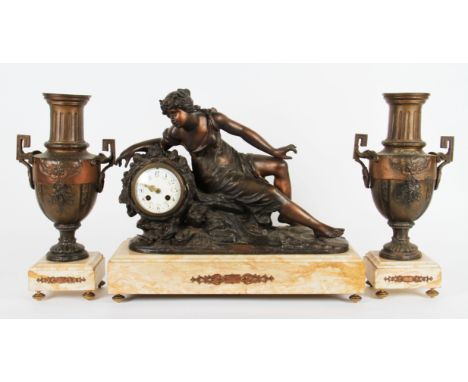 An early 20th Century clock garniture, clock having bronzed sculpture of a semi nude reclining nude with plaque to front ‘Sur