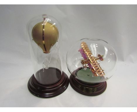 A glass model of a Bristol Bulldog and a hot air balloon in glass domes