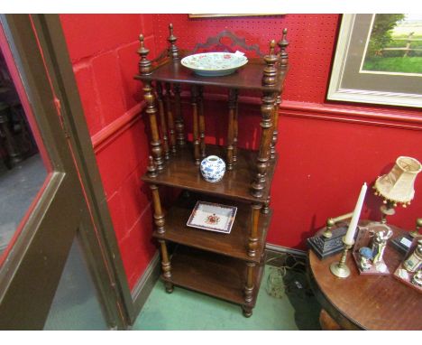 A four tier Canterbury whatnot with fret work decoration on turned supports with finial decoration, 119cm tall x 47cm wide 
