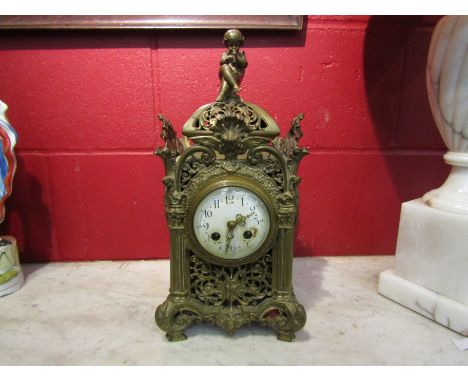 A 20th century pierced brass mantel clock surmounted by cherub, 41cm tall