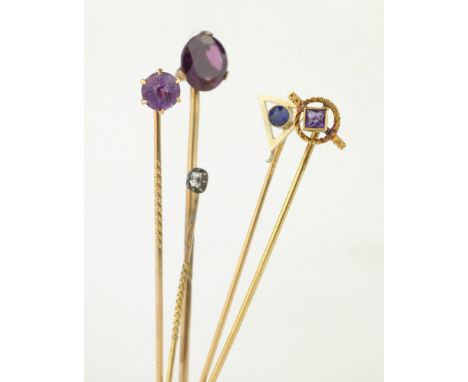 Four 14ct gold stick pins set with sapphire, diamond and amethysts tested or stamped 14K and an amethyst stick pin tested to 