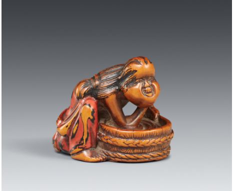 Netsuke einer pummeligen Frau, sich waschend. Holz mit partieller negoro-Lackfassung. Frühes 19. Jh.Kniend vor einem Waschtro