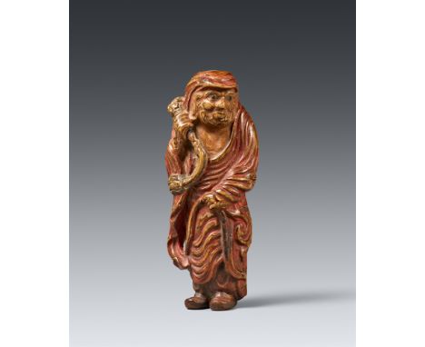 Netsuke des stehenden Daruma. Holz mit Resten einer Farbfassung (saishiki). 19. Jh.Mit eng zusammengestellten Füßen und in ty