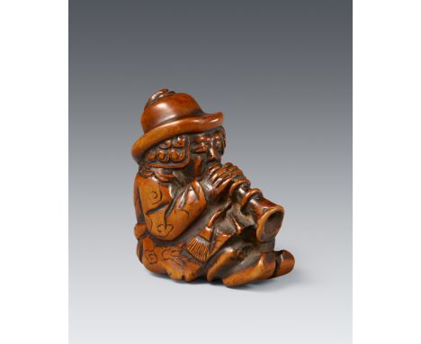 Großes Netsuke eines sitzenden Holländers. Buchsbaum. 18./frühes 19. Jh.Mit angewinkelten Knien sitzend und eine Schalmei spi