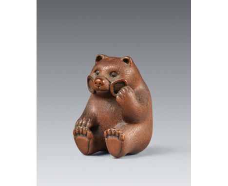 Netsuke eines jungen Bären. Buchsbaum. 1980er-JahreSign. in aus dem Fell ausgesparter Reserve: MasamiSitzend in der Art eines