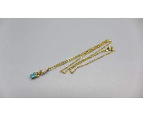A 9ct gold, blue topaz and diamond pendant on a plated chain 