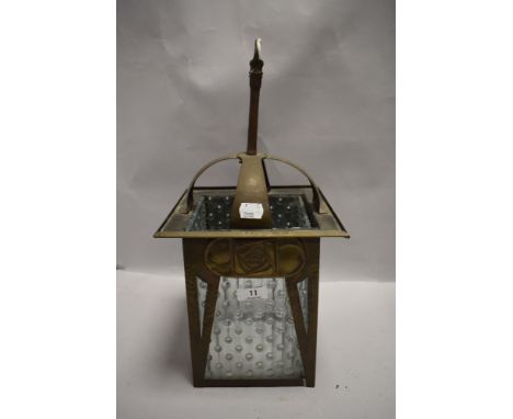 An antique hammered brass and textured glass lamp shade having Rennie Mackintosh styling.
16.5" base to hook, 8" x *" widest 