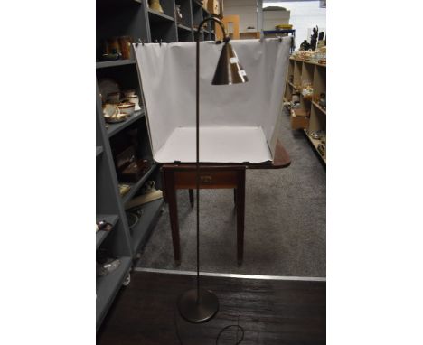 A modern bronzed metal standard lamp with adjustable conical shade