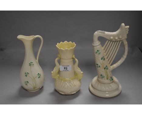 Three pieces of Belleek porcelain, sea serpent handled vase, harp ornament (green backstamps) and a shamrock decorated jug (b