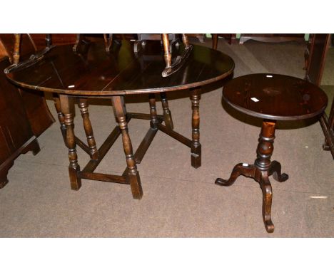 An oak gate leg dining table and a modern circular top tripod table 