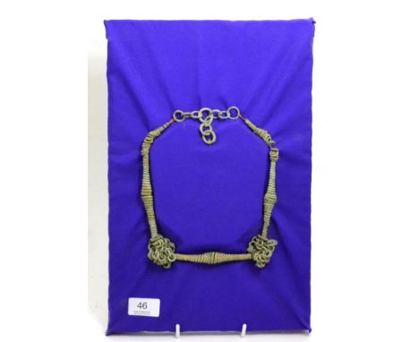 A Viking bronze necklace, circa 9th-12th century, having three waisted spiral sections separated with multiple rings, mounted