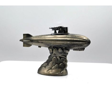 A late 1920’s German metal desk ornament. In the style of the ‘Graf Zeppelin LZ127’ above a central plinth designed as clouds