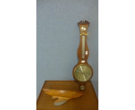 A barometer and model sailing boat hull 