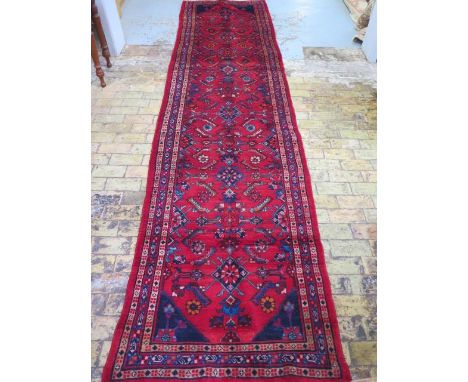 A hand knotted woollen Hamadan runner, 4.37m x 1.07m, some wear but colours bright 