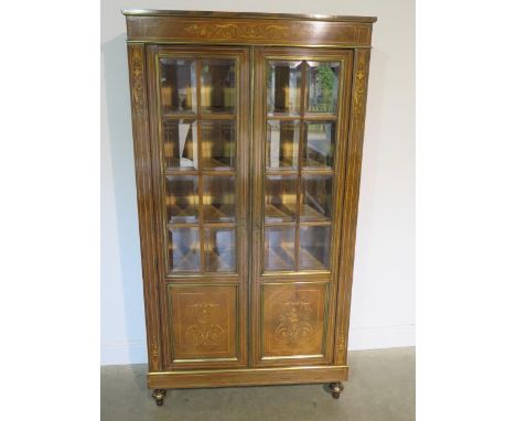 A French 19th century rosewood inlaid bookcase, the glazed doors opening to reveal five internal shelves over a rectangular p