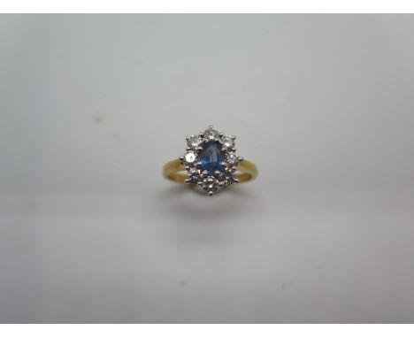 A hallmarked 18ct yellow gold sapphire and diamond cluster ring, the sapphire measures approx 6mm x 4mm x 2.7mm, 0.54ct, surr