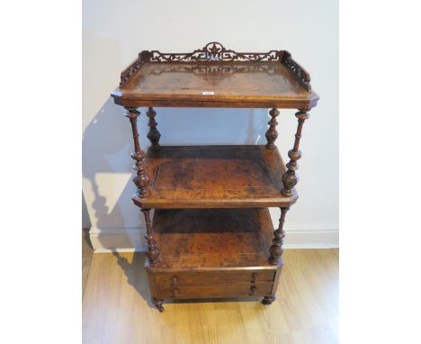 A 19th century burr walnut whatnot with carved gallery and two frieze doors united by turned supports and raised on ceramic c