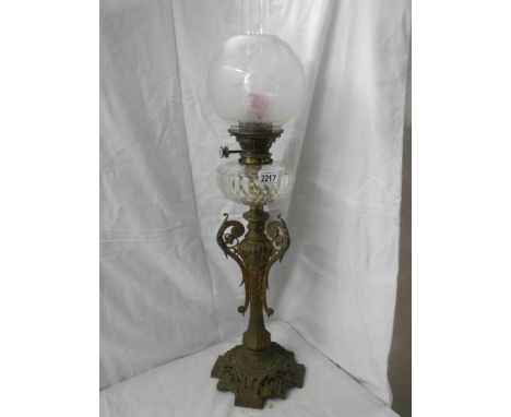 A Victorian brass oil lamp with cut glass font. ****Condition report**** Shade and chimney undamaged. Total H 82cm. Font has 