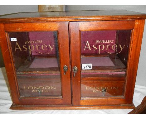 A mahogany jewellery cabinet signed for Asprey's.