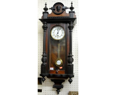 An early 20th century walnut and ebonised Vienna drop trunk wall clock