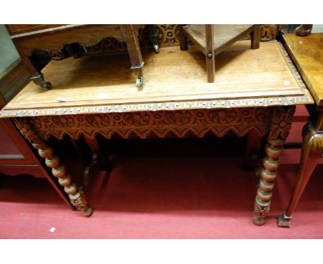 An early 20th century carved oak ledgeback hall table, raised on bobbin turned supports, w.104cm