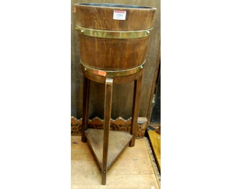 An early 20th century coopered oak circular planter, with triangular undertier, h.71cm