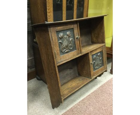 ART NOUVEAU OAK WALL-MOUNTING CABINETtwo shelves each with copper embossed cupboard door to opposing sides, 61cm high, 60.5m 