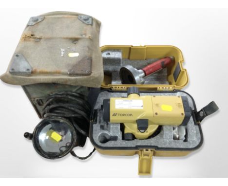 A Topcon surveyor's level in case together with a vintage military spot lamp with canvas cover and lacquered tin carry box