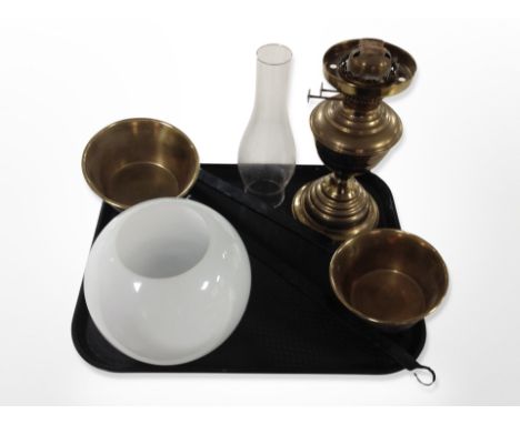 A brass oil lamp with opaque glass shade and chimney together with two brass long handled pans 