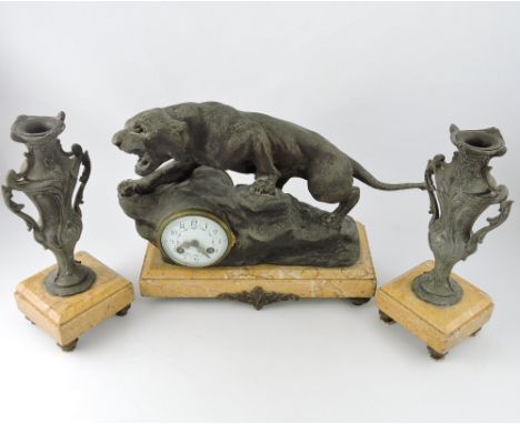 An early 20th century spelter clock garniture, cast as a leopard on a rocky outcrop, the enamel clock dial with floral swags 