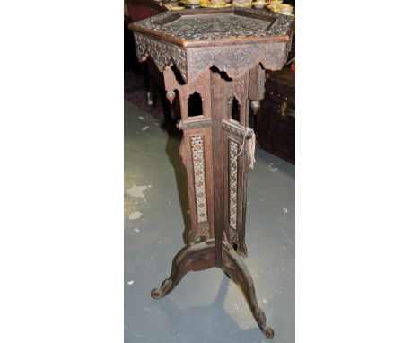 A Damascus carved hardwood plantstand on pierced tripod.
