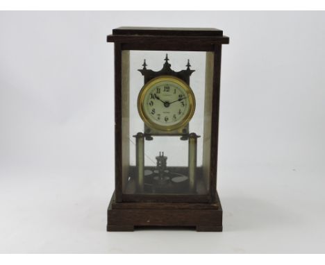 A mantel clock within an oak case, with a white dial set out in Arabic numerals, H. 29cm.