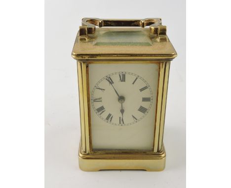 An early 20th century carriage timepiece, with a corniche case and white enamel dial set out in Roman numerals, H. 13cm. 