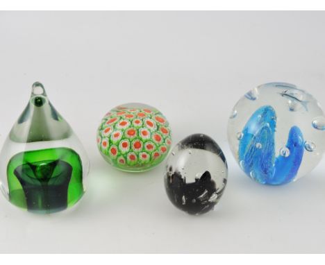 A large glass globe paperweight, set with dolphins; together with three further paperweights. (4)