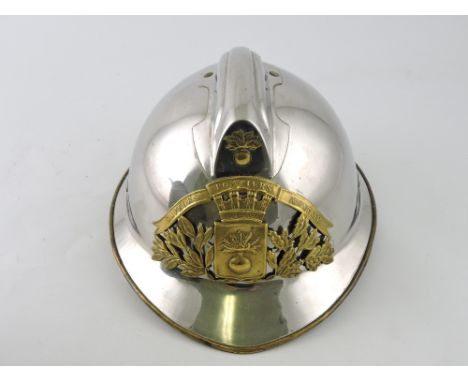 A mid-20th century French fireman's helmet, polished steel with brass fittings, and a leather skull.