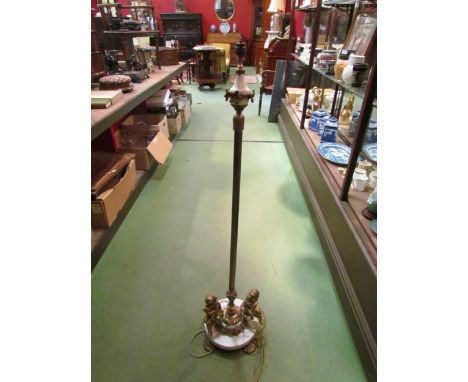 A gilt and marble column form standard lamp with seated brass figures to base on lion paw feet, 123cm high approximately 