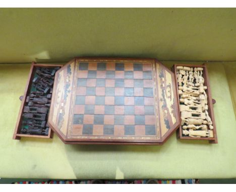 A carved Madagascan chess set with figural pieces 