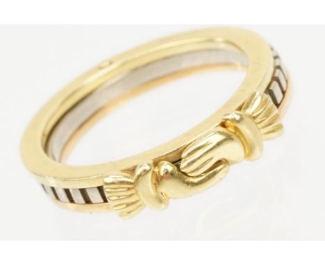 18ct gold tri tone ring constructed from three interlocking rings with clasped hands to the head, opening to reveal engraved 