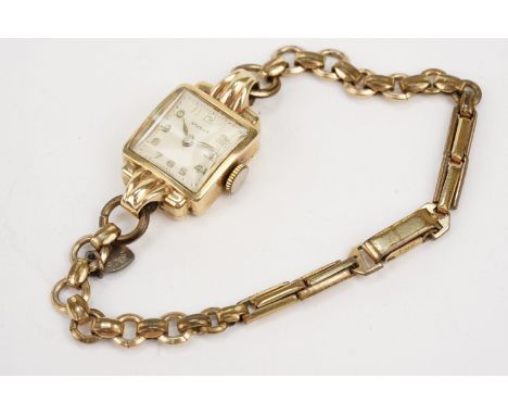 9ct gold Ravella wrist watch having a square face on a gold plated strap. Case measures approx 15mm wide. Hallmarked London 1