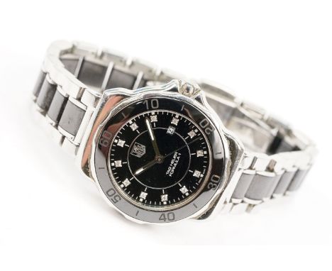 Tag Heuer Formula 1 ladies wrist watch. The watch having a round face with black dial with diamond set hour markers, and blac