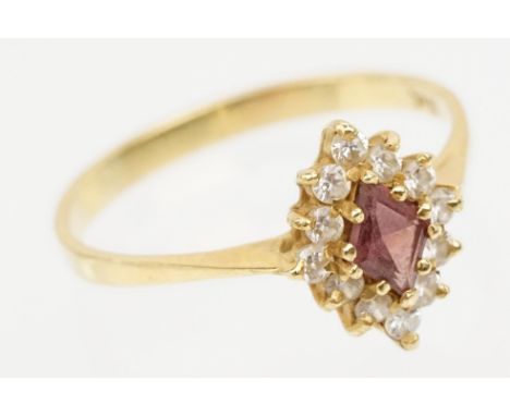 18ct gold ruby and cz ring. The ring being set with a step cut ruby with a halo of round cut cz's. Band marked 18ct. Size O.5