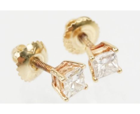 Pair of 14ct gold and diamond stud earrings. Each earring set with a square princess cut diamond in prong settings with a thr