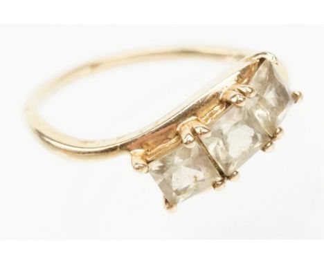 9ct gold and Csarite three stone ring. The ring  being set with three square mixed cut stones in a crossover setting. Hallmar