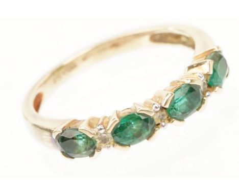 9ct gold synthetic emerald and diamond line ring. The ring being set with oval cut emeralds with diamond accent stones. marke