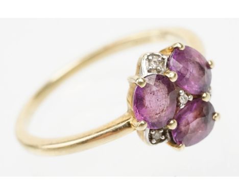 9ct gold Comeria garnet and diamond cluster ring. The ring being set with three oval cut purple garnets with diamond accent s