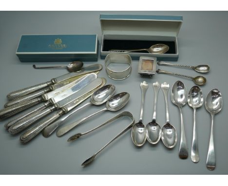 Six silver handled butter knives, a collection of Georgian and later silver spoons, a silver stamp box, a silver napkin ring 