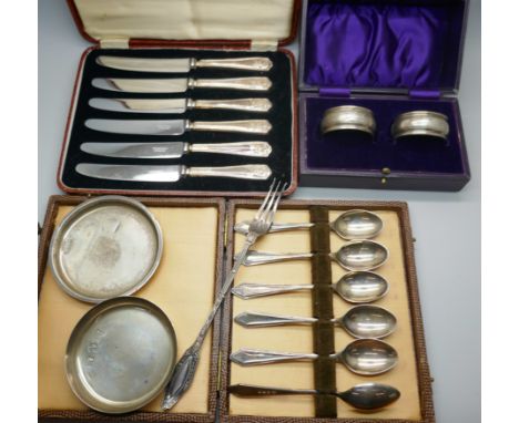 Two small circular silver dishes, two boxed silver napkin rings, boxed set of six silver handled knives, a boxed set of six s