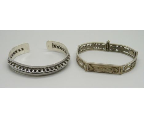 An Egyptian white metal bracelet and a silver bangle 