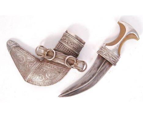 An antique South Arabian Khanjar Omani dagger and scabbard having a silver white metal decorated handle fixed to horn and a c